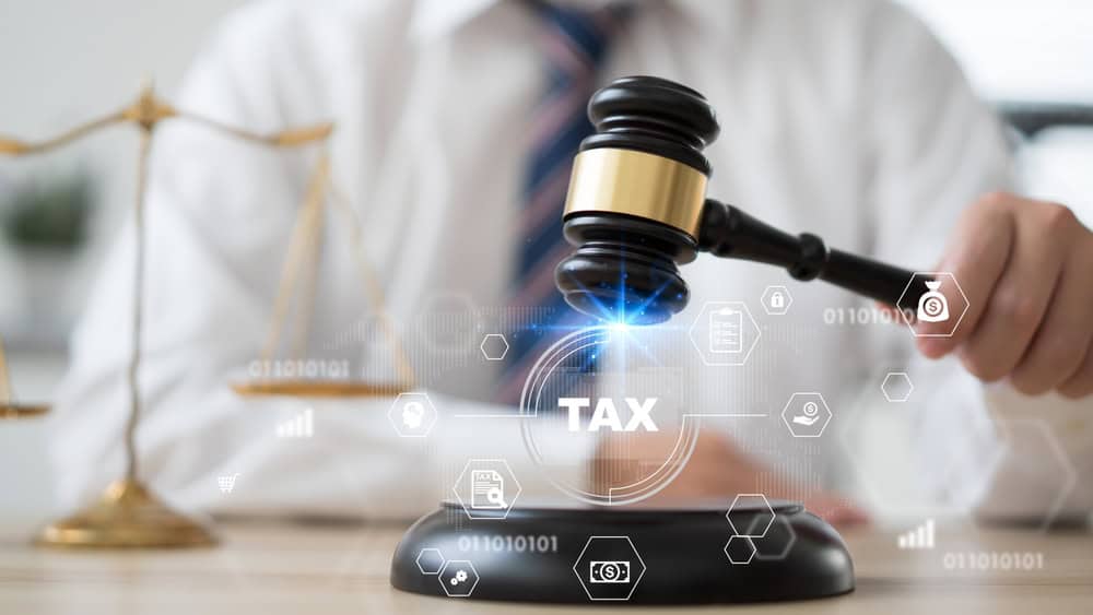 Gavel striking with digital tax symbols and scales of justice, symbolizing legal and tax implications for dental practices and CPAs.